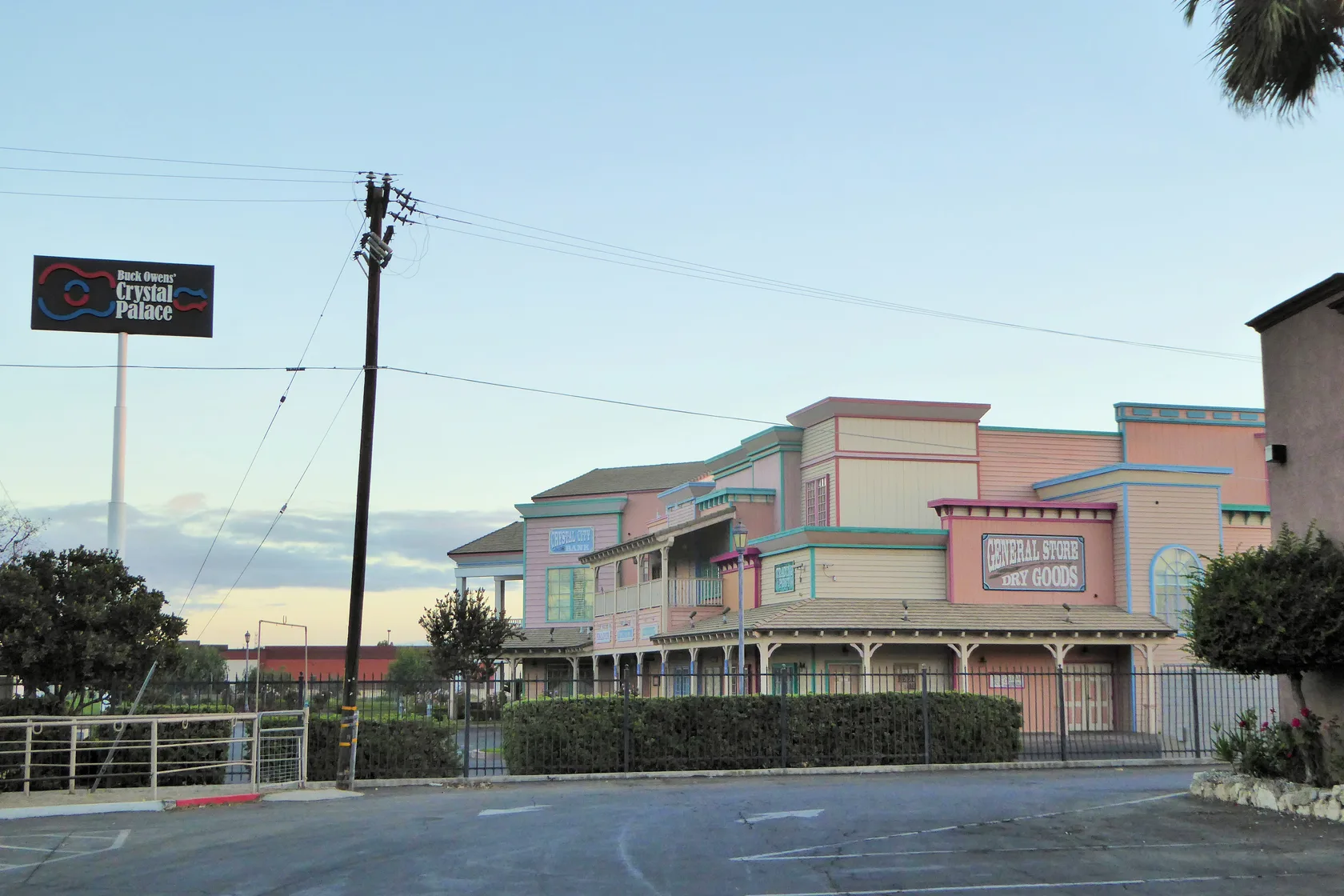The low pastel frontage and roadside sign of Buck Owens' Crystal Palace in Bakersfield at dusk